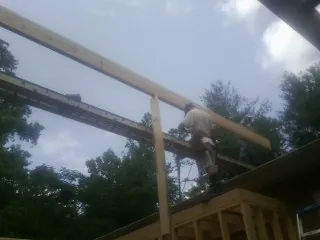 Carpenter setting a ridge beam over a new addition frame — Ice Dam Removal by Roofing Brothers in Ottertail